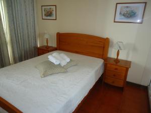 波尔蒂芒Apartamentos Varandas da Rocha的一间卧室配有一张带2个床头柜和2盏灯的床。