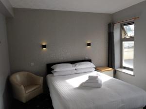 巴基Marine Hotel的卧室配有白色的床和椅子
