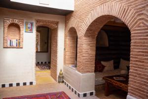 马拉喀什本萨利赫摩洛哥传统庭院住宅的一间设有两个拱门和一个砖砌壁炉的房间