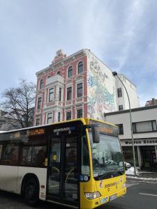 不来梅港Hafen 12的停在大楼前的一辆黄色和白色的公共汽车