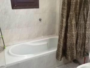 赫尔格达Mama Africa的浴室配有白色的浴缸和淋浴帘