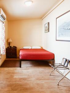 托诺帕Old Brewery Hostel的一间卧室配有红色的床和椅子