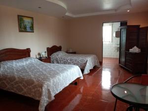 迦太基Hotel Las Brumas的一间带两张床和一张桌子的卧室以及一间浴室
