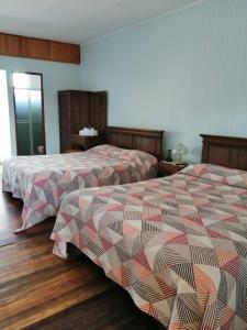 迦太基Hotel Las Brumas的两张位于酒店客房的床,配有两张sidx sidx单人床