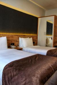 博卢ESKOPPremium OTEL的酒店客房设有两张床和黑色墙壁。