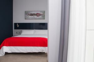 普埃托利亚诺圣欧拉利娅酒店的一间卧室配有一张带红色毯子的床