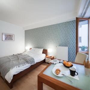 布达佩斯罗尔德公寓的一间卧室配有一张床和一张带一盘食物的桌子