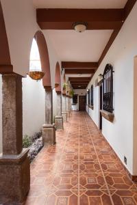 科马亚瓜APARTAMENTOS CASCO HISTORICO COMAYAGUA的走廊上设有瓷砖地板和拱廊
