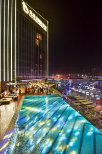 珠海珠海龙珠达国际酒店(拱北口岸店）的一座游泳池,在晚上在建筑物前