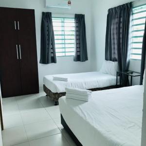 斯里曼绒Motel Fasa2B的酒店客房设有两张床和窗户。