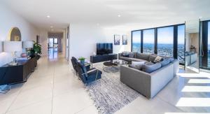 墨尔本Melbourne City Apartments Panoramic Skyview Penthouse的客厅配有沙发、椅子和电视