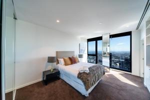 墨尔本Melbourne City Apartments Panoramic Skyview Penthouse的一间卧室设有一张床和大窗户