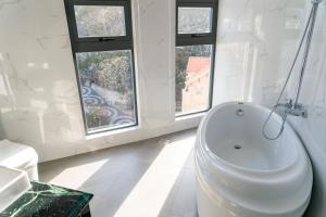 头顿Sun Hill Hotel的白色的浴室设有浴缸和窗户。