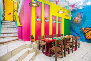 巴亚尔塔港CASA MARÍA MALECÓN的餐厅拥有色彩缤纷的墙壁和桌椅
