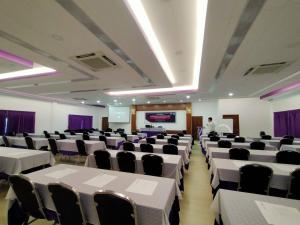 乌泰他尼府Uthaithani Resort的一间会议室,配有白色的桌椅和主讲人