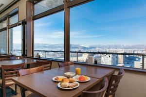 旭川旭川普樂美雅凱賓酒店的一张带餐盘的桌子,享有城市美景