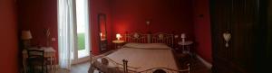圣费利切德尔贝纳科B&B Solstizio d'estate的一间卧室设有一张红色墙壁和窗户的床