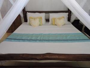 迪亚尼海滩迪亚尼海滩度假屋的一张带白色床单和枕头的床