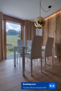 摩德纳迪-坎皮格里奥Chalet Golf Campiglio / LuxApt / fronte piste-impianti-golf的一间配备有白色桌椅的用餐室