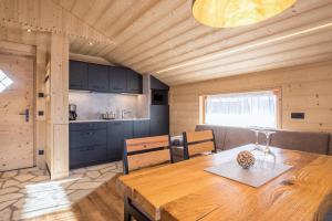 塞尔瓦德伊莫利尼Chalets Reisnock - Hochgruberhof的厨房以及带木桌的用餐室。