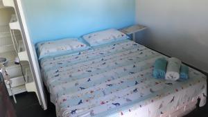 坎布里Alebelhinha Residencial Camburi Pousada的卧室内的一张小床,卧室内有蓝色的墙壁