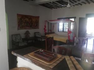 瓦塔穆Chiky Villa的一间带桌椅的用餐室和一间带用餐室的房间
