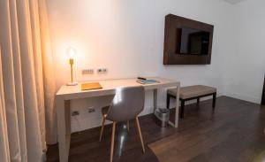 拉拉古纳拉古纳大酒店的一张桌子、椅子、一盏灯和一台电视