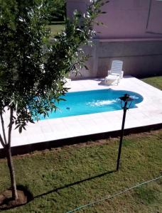 VictoricaCabañas bajos medanales的房屋旁带椅子的游泳池