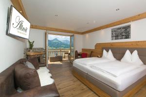 圣沃尔夫冈阿尔特罗伊特霍夫酒店的一间卧室配有一张床、一张沙发和一个窗口