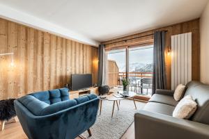 拉普德兹Residence Hameau de Clotaire Alpe d'Huez - by EMERALD STAY的带沙发和电视的客厅