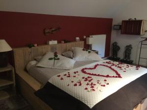 通厄伦安缇奎库克住宿加早餐旅馆的一间卧室,床上有红色的鲜花