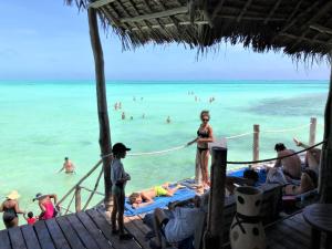 江比阿Reef & Beach Resort - Spa Jambiani的站在海滩码头上的女人