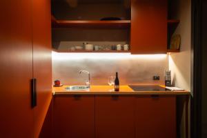 卡塔尼亚Palazzo Scammacca的厨房配有橙色橱柜和水槽