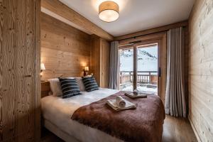 拉普德兹Apartment Wapa Alpe d'Huez - by EMERALD STAY的一间卧室设有一张大床和一个窗户。