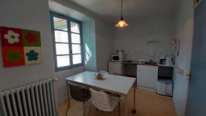 Saint-PrixDomaine Sela的厨房配有白色的桌子和窗户。