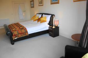伊尔弗勒科姆橄榄枝酒店的一间卧室配有一张带黄色枕头和桌子的床