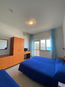 普拉亚·阿马勒Hotel Germania的一间卧室配有蓝色的床、梳妆台和电视。