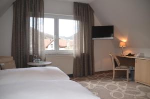 莱因斯韦勒山庄酒店及餐厅的配有一张床、一张书桌和一扇窗户的酒店客房
