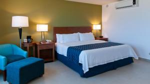 卡波圣卢卡斯卡波圣卢卡斯智选假日酒店的配有一张床和一把椅子的酒店客房