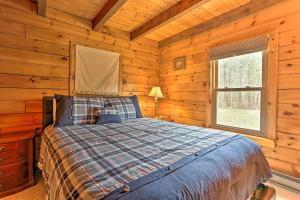 东斯特劳兹堡Dog-Friendly Pocono Mtns Cabin with Deck Near Hiking的小木屋内一间卧室,配有一张床