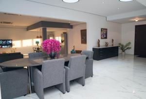 WanicaLiberdada Villa SURINAME的一间设有桌子和紫色鲜花的用餐室