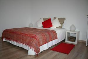 波尔蒂芒Apartment Portimao Old Town的卧室配有带红色枕头的大型白色床
