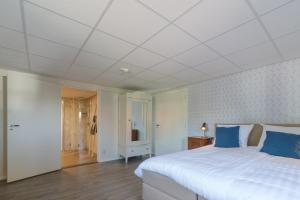 WolphaartsdijkHerberg de Griffioen的卧室配有带蓝色枕头的大型白色床