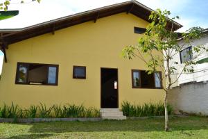 帕拉蒂Pouso Paratiense Jabaquara的前面有一棵树的黄色房子