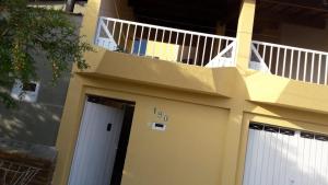 卡舒埃拉保利斯塔Santa Helena Pousada的一座带白色门和阳台的建筑