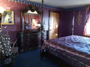 AnnandaleThe Thayer的一间卧室配有一张床和一面大镜子