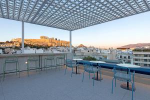 雅典Acro Urban Suites的一个带桌椅的庭院,享有城市美景