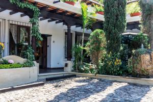 危地马拉安地瓜Villa 14 Santa Ines Antigua Guatemala的一座带树木和植物的庭院的房子