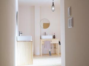 金泽角安宾馆的一间带两个盥洗盆的浴室和一张带镜子的书桌