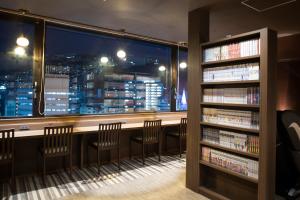 长崎Dormy Inn Premium Nagasaki Ekimae的图书馆,晚上可欣赏到城市美景